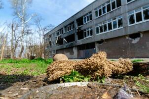 vuil speelgoed Aan de achtergrond van een burn-out vernietigd school- in een verlaten stad in Oekraïne foto