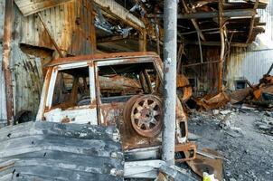 verbrand auto Aan de straat van de geruïneerd stad foto