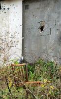 oud wijnoogst stoel Aan de achtergrond van een muur met een gat van een de mijne in Oekraïne foto