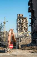 bouw uitrusting vernietigt huizen beschadigd gedurende de oorlog in Oekraïne foto