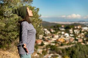 vrouw ontspant in de garraf natuurlijk park en ontvangt de zon stralen Aan haar gezicht. foto