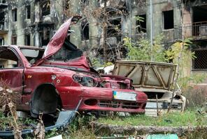 beschadigd en geplunderd auto's in een stad in Oekraïne gedurende de oorlog foto