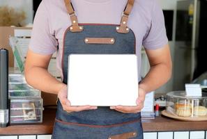 barista houdt een tablet met een leeg scherm vast om het menu van de klant in het café te ontvangen. foto