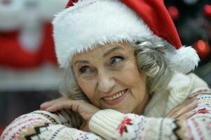 portret van gelukkig senior vrouw in de kerstman hoed foto