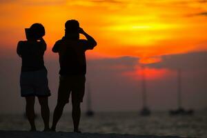 paar op strand bij zonsondergang foto