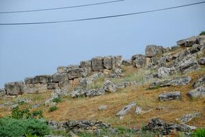 kalksteen blokken een aardbeving verwoest muur van stad van hierapolis. foto