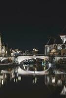 visie Aan Sint-Michielsbrug in de centrum van gent door de rivier- lei gedurende de nacht. van belgië meest beroemd historisch centrum. gent waterkant gedurende middernacht foto