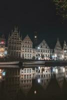 middeleeuws gebouwen Aan graslei straat in de centrum van gent door de rivier- lei gedurende de nacht. van belgië meest beroemd historisch centrum. gent waterkant gedurende middernacht foto