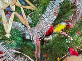 gelukkig nieuw jaar knus huis interieur met Kerstmis boom en slingers klein rood ballen rijst- rietje ster vorm geven aan. wazig lichten gouden bokeh.merry Kerstmis achtergrond. foto