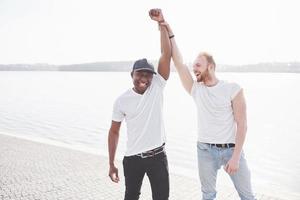 twee jonge multi-etnische vrienden die met elkaar praten en glimlachen terwijl foto