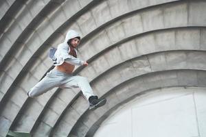 een jonge man springt. parkour in stedelijke ruimte, sportieve activiteit. foto