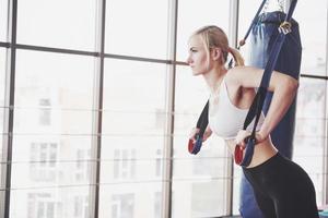 vrouwen doen push-ups training armen met trx fitness bandjes in de sportschool concept workout gezonde levensstijl sport