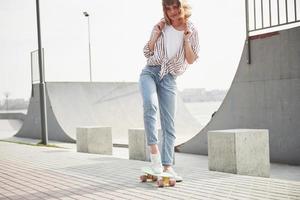 een jonge sportvrouw die op een skateboard in een park rijdt. foto