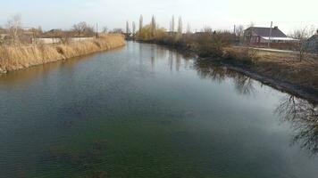 rivier- eric stroom in de dorp in de de lente. Ondiep rivier, langzaam vloeiende in de dorp. foto