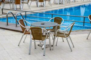 metaal tafels en stoelen met rieten stoelen in buitenshuis cafe. foto