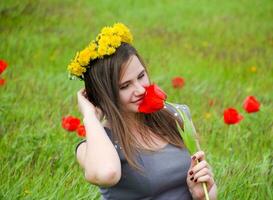 een meisje met een krans van paardebloemen Aan haar hoofd. mooi fee foto