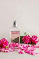 een chique fles van vrouwen parfum en een delicaat bloemblaadjes bloem, thee roos met een rozenknop . voorkant verticaal visie. naamloos fles voor Product invoering foto