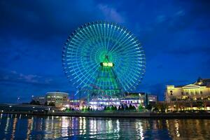 een nacht verlichte ferris wiel in yokohama telefoto schot foto