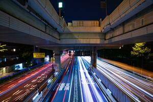 een nacht timelapse van de verkeer jam Bij de stad straat onder de snelweg breed schot foto