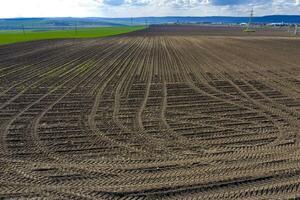 rijen van bodem na ploegen met sporen van banden. horizontaal visie met perspectief. foto
