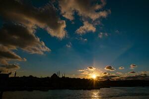 Istanbul visie Bij zonsondergang met silhouet van moskeeën en dramatisch wolken foto