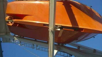 een reddingsboot in geval van een ongeluk in de haven of Aan een schip. de oranje boot foto