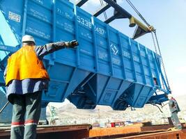 verhogen de hopper auto voor lossen Aan een lading schip. hijs- operaties in de haven. foto