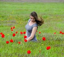 mooi fee jong meisje in een veld- tussen de bloemen van tulp foto