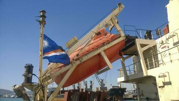 een reddingsboot in geval van een ongeluk in de haven of Aan een schip. de oranje boot foto