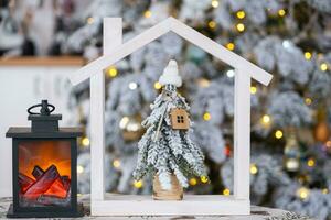 sleutel Aan Kerstmis boom en klein huis Aan knus huis met Kerstmis decor Aan tafel van feestelijk wit keuken. geschenk voor nieuw jaar. verzekering, in beweging naar nieuw huis, hypotheek, huur en echt landgoed foto