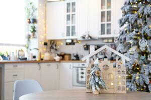 sleutel Aan Kerstmis boom en klein huis Aan knus huis met Kerstmis decor Aan tafel van feestelijk wit keuken. geschenk voor nieuw jaar. verzekering, in beweging naar nieuw huis, hypotheek, huur en aankoop echt landgoed foto