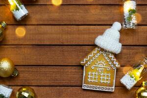 klein peperkoek huis Aan houten achtergrond met Kerstmis decor lay-out en kopiëren ruimte. geschenk voor nieuw jaar, kerstmis. gebouw, projecteren, in beweging naar nieuw huis, hypotheek, huur en aankoop echt landgoed foto