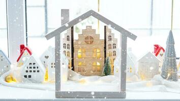 knus Kerstmis decor klein huis van klein grootte Aan venster dorpel met sneeuw buiten de venster. geschenk voor nieuw jaar. verzekering, in beweging naar nieuw huis, hypotheek, huur en aankoop echt landgoed foto