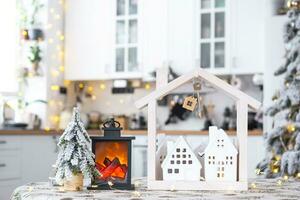 sleutel en klein huis van een klein grootte Aan knus huis met Kerstmis decor Aan tafel van feestelijk wit keuken. geschenk voor nieuw jaar. verzekering, in beweging naar nieuw huis, hypotheek, huur en aankoop echt landgoed foto