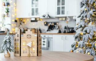 sleutel en klein huis van een klein grootte Aan knus huis met Kerstmis decor Aan tafel van feestelijk wit keuken. geschenk voor nieuw jaar. verzekering, in beweging naar nieuw huis, hypotheek, huur en aankoop echt landgoed foto