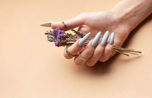 detailopname van een vrouw handen met grijs gemanicuurd nagels foto