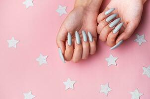 handen met grijs manicure Aan een roze achtergrond foto