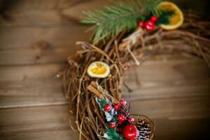 Kerstmis decoratie met pijnboom kegels, Spar takken, rood bessen en sinaasappels foto