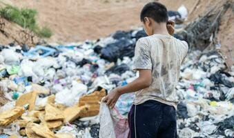 arm kinderen Aan de vuilnis dump en selecteren plastic verspilling naar verkopen, kinderen niet in school, armoede. foto