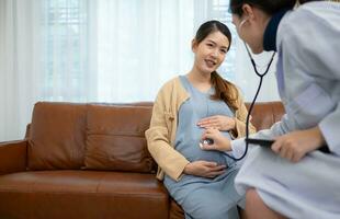 Aziatisch zwanger vrouw bezoek gynaecoloog dokter Bij medisch kliniek voor zwangerschap consultant. dokter onderzoeken zwanger buik voor baby en moeder gezondheidszorg controleren omhoog. foto