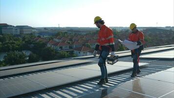 beide van technici is installeren zonne- panelen Aan de dak van de magazijn naar verandering zonne- energie in elektrisch energie voor gebruik in fabrieken. foto