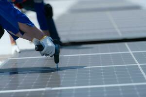 beide van technici is installeren zonne- panelen Aan de dak van de magazijn naar verandering zonne- energie in elektrisch energie voor gebruik in fabrieken. foto