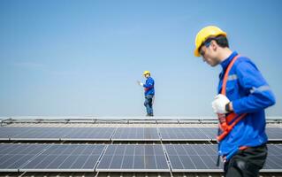 beide van technici is installeren zonne- panelen Aan de dak van de magazijn naar verandering zonne- energie in elektrisch energie voor gebruik in fabrieken. foto