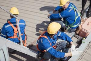 arbeiders Aan een bouw plaats nemen een breken Aan de dak van een gebouw. foto