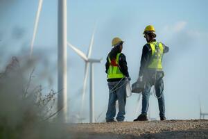 ingenieur en arbeider bespreken Aan een wind turbine boerderij met blauwdrukken foto