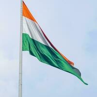 indiase vlag hoog op connaught plaats met trots in blauwe lucht, indiase vlag wapperen, indiase vlag op onafhankelijkheidsdag en republiek dag van india, tilt-up shot, wuivende indische vlag, har ghar tiranga foto