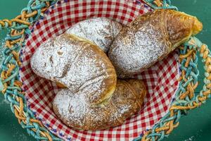 vers gebakken croissants met gepoederd suiker in een mand foto