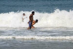 goa, Indië, december 10, 2023 - niet geïdentificeerd toeristen genieten van Bij Arabisch zee gedurende de ochtend- tijd in calangute strand goa, Indië, oceaan strand visie vroeg ochtend- tijd foto