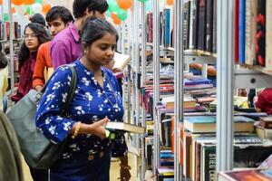 Delhi, Indië, september 09 2023 - divers leeftijd groep mensen lezing verscheidenheid van boeken Aan plank binnen een boekenstalletje Bij Delhi Internationale boek eerlijk, selectie van boeken Aan Scherm in jaar- boek eerlijk foto