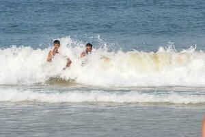 goa, Indië, december 10, 2023 - niet geïdentificeerd toeristen genieten van Bij Arabisch zee gedurende de ochtend- tijd in calangute strand goa, Indië, oceaan strand visie vroeg ochtend- tijd foto